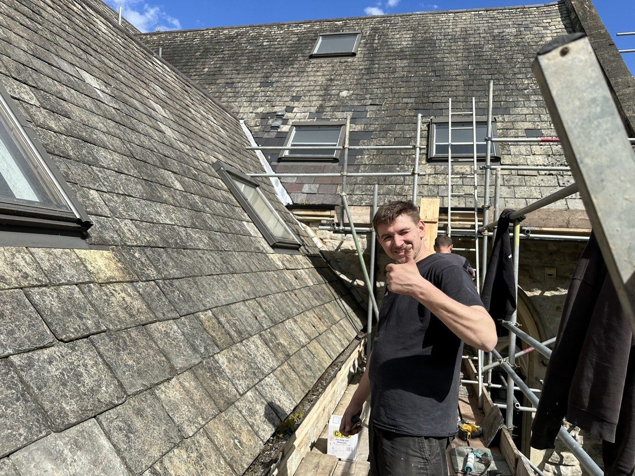 Perlini roofer on a slate roof beside the scaffolding