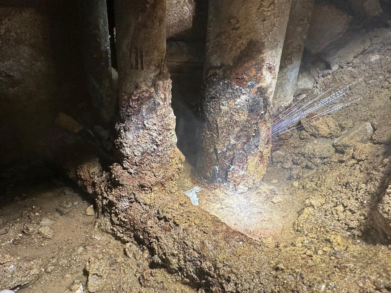 Water spraying from a corroded underground pipe