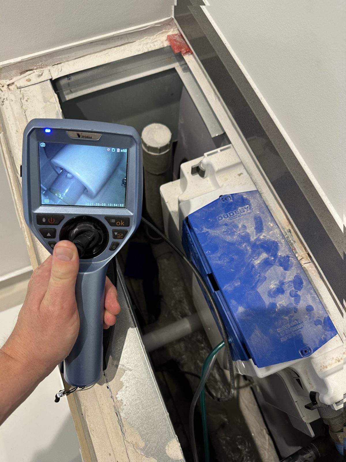 Borescope inspecting a leak inside a toilet cistern