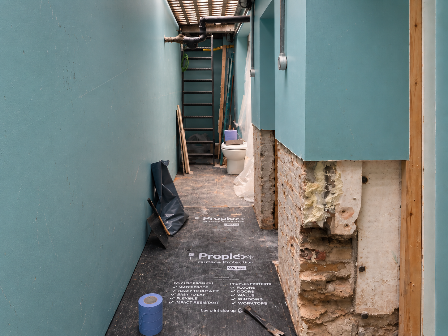 Room with damp-affected wall stripped back before treatment