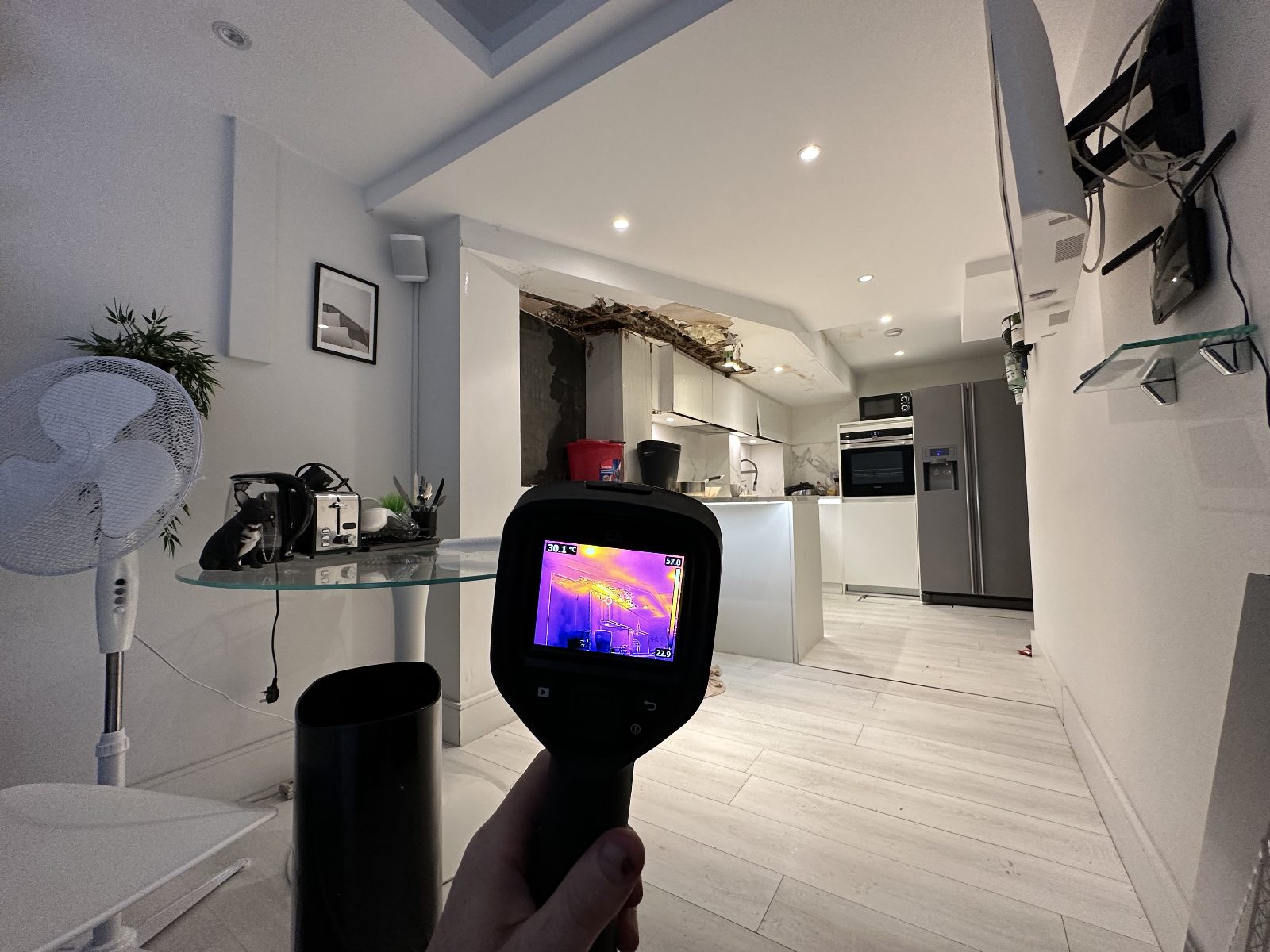 Thermal camera checking leak damage to a kitchen ceiling